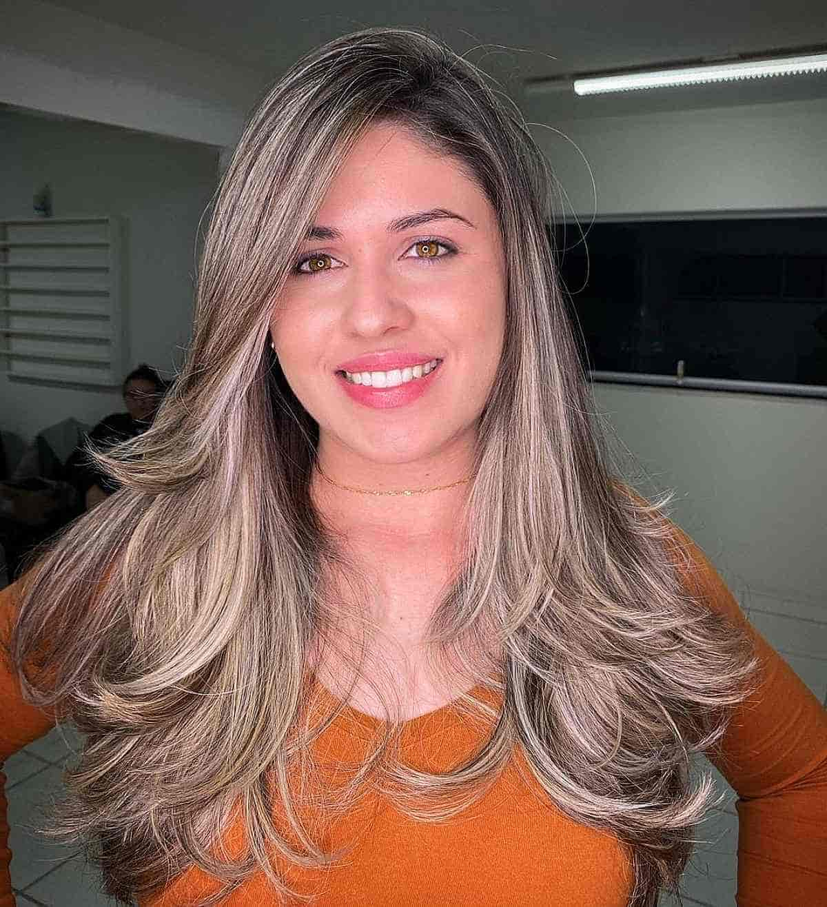 Corte degradado com varredura loira acinzentada e franja penteada na lateral