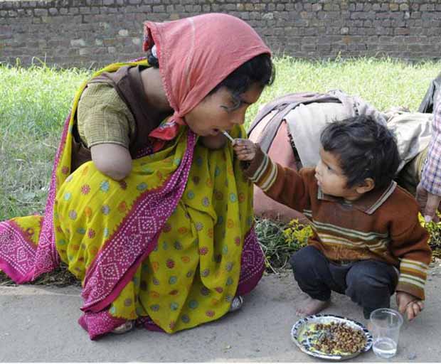 Un enfant de 2 ans donnant à manger à sa maman handicapée
