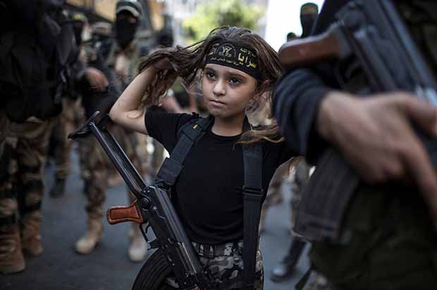 Une enfant palestinienne portant un fusil