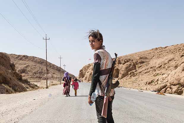 Une fille yazidi portant un fusil d’assaut pour protéger sa famille contre Isis