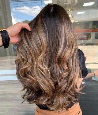 cabelo ondulado grosso com mechas castanhas claras