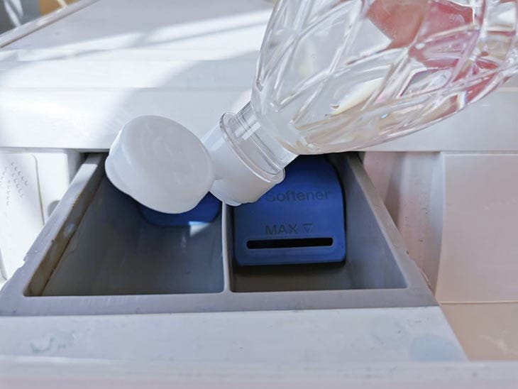 Add white vinegar to the detergent drawer of the washing machine