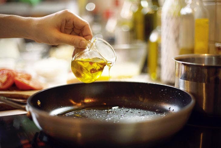 Agregar aceite de cocina a una sartén
