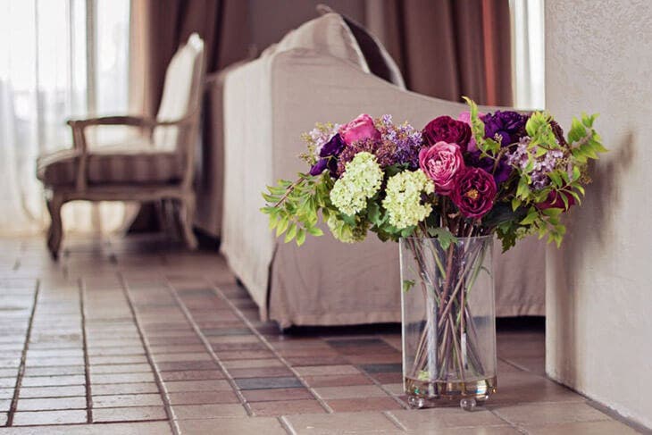 Des fleurs dans une vase placees par terre