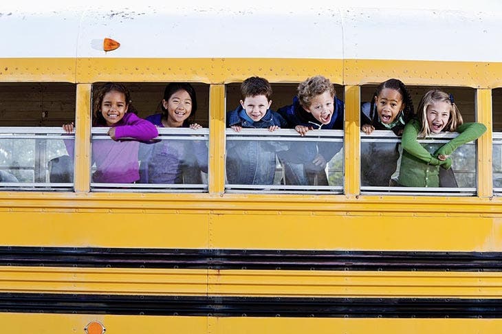 Students in a bus with a white roof