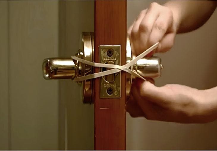 Wrap a rubber band around door handles