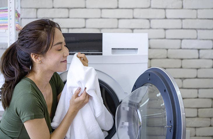 A woman enjoying the smell of her laundry
