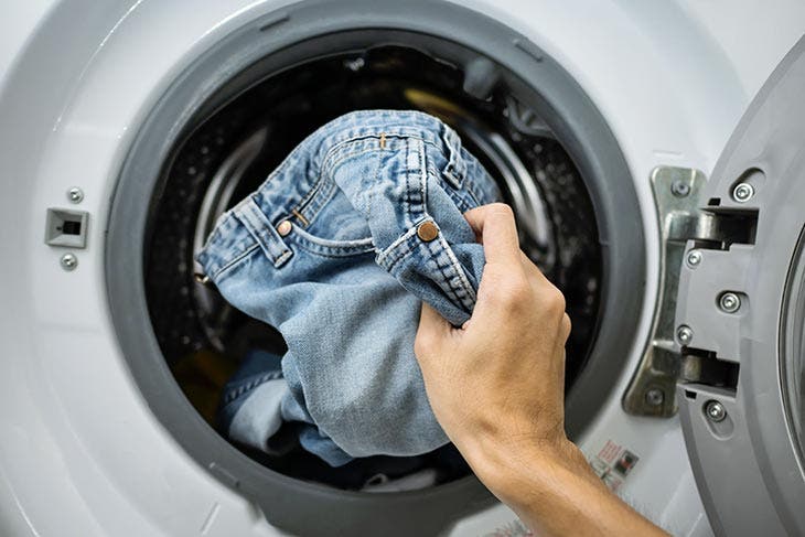Jeans in die Waschmaschine stecken