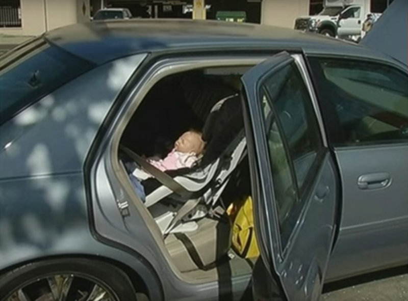 Le policier ouvre la fenêtre de la voiture pour sauver un bébé immobile