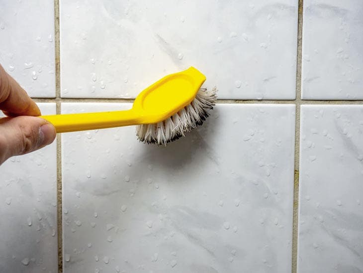 Cleaning shower joints with an old toothbrush