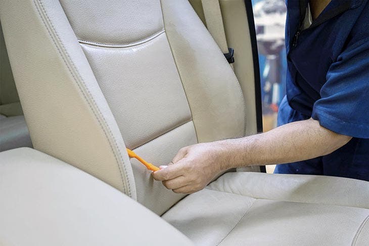 Cleaning the car seat with a toothbrush