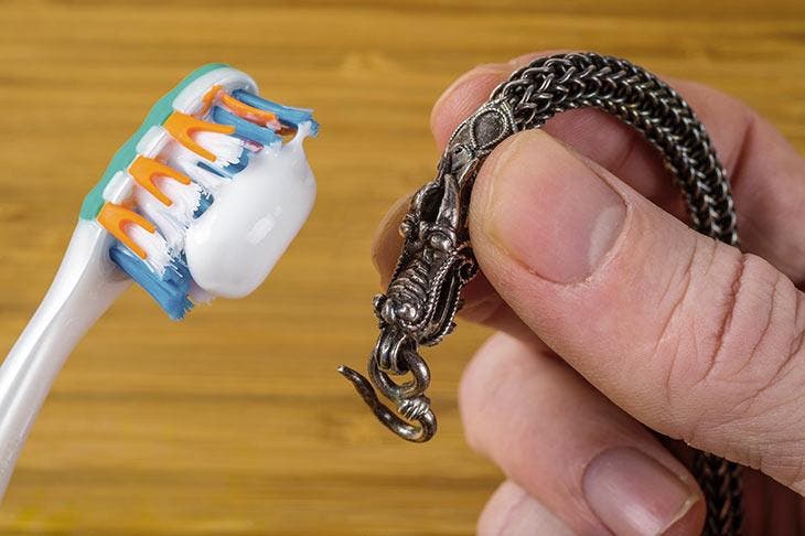 Cleaning a silver bracelet with toothpaste.