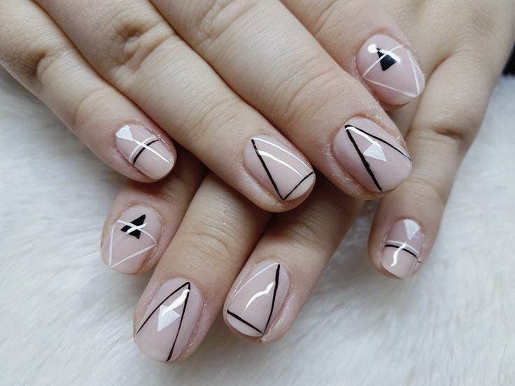 Ongles Courts avec des motifs géométriques noirs sur base nude Ongles Courts avec des motifs géométriques noirs sur base nude