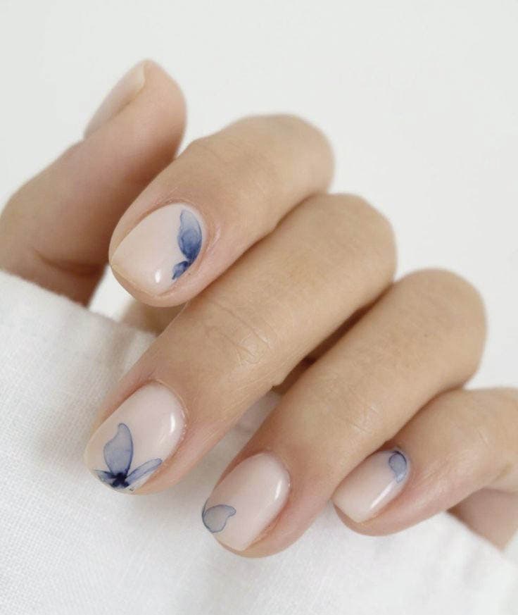Ongles courts aux teintes pastel nude et papillon bleu Ongles courts aux teintes pastel nude et papillon bleu