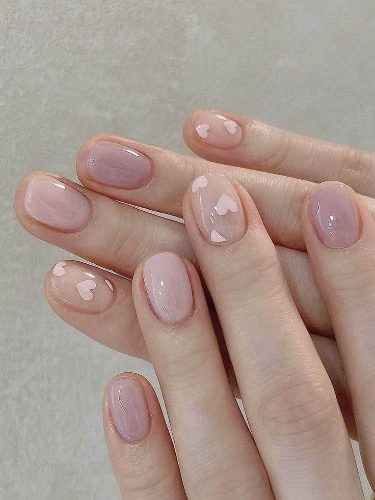 Ongles courts avec des motifs en forme de cœur rose sur base nude Ongles courts avec des motifs en forme de cœur rose sur base nude