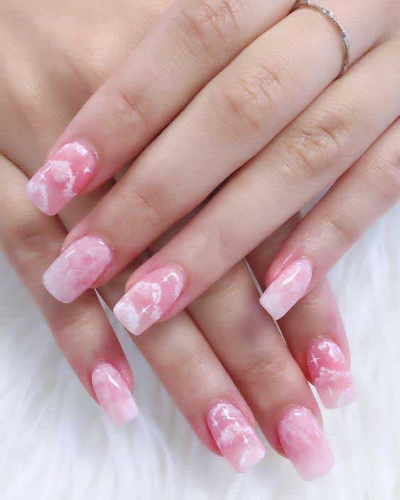 Unhas rosa em pó com desenhos em forma de nuvem