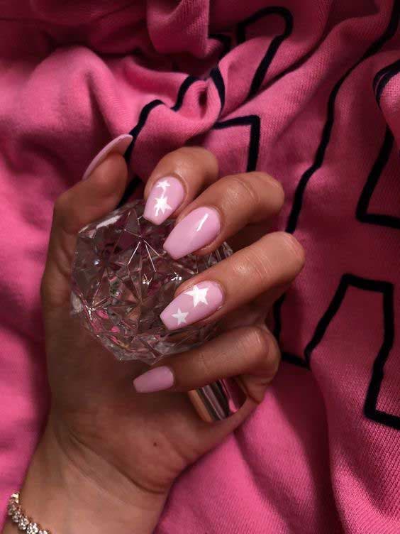 Unhas rosa em pó com desenhos em formato de estrela