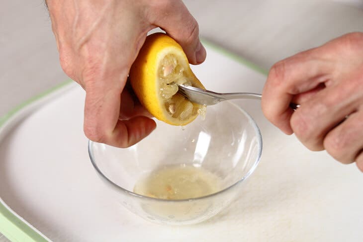 Spremere un limone con una forchetta.