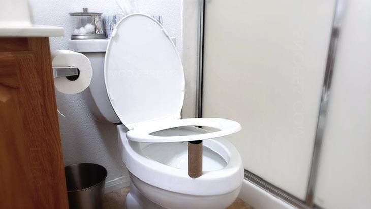 Empty toilet paper roll placed under the seat