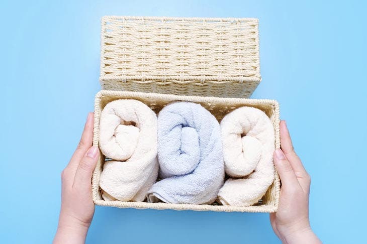 Towels rolled up in a wicker drawer