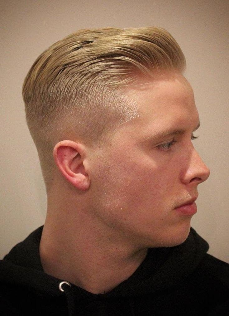 Taper bas sur cheveux courts blonds coiffés en arrière Taper bas sur cheveux courts blonds coiffés en arrière