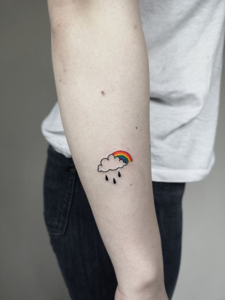 Tatouage nuage pluvieux avec arc-en-ciel derrière Tatouage nuage pluvieux avec arc-en-ciel derrière