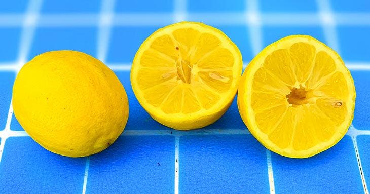 Un limón cortado por la mitad y un limón entero