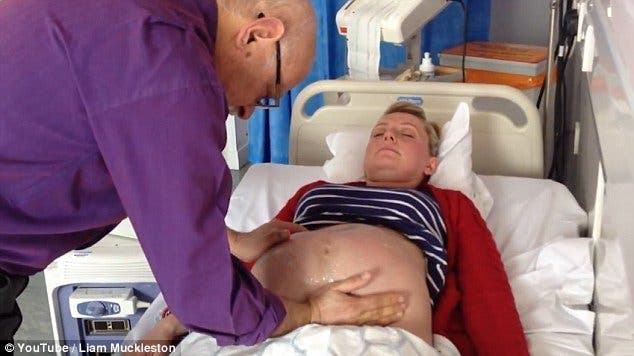 Un médecin appuie sur le ventre d’une femme enceinte