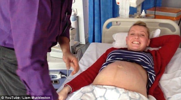 Un médecin appuie sur le ventre d’une femme enceinte