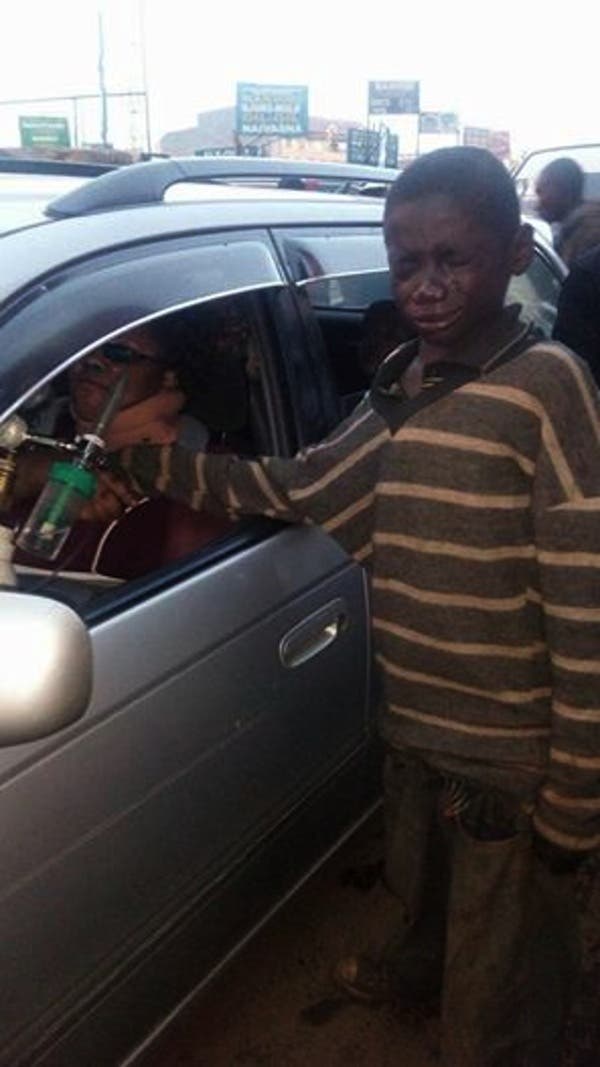 Un petit garçon sans-abri approche une voiture au Kenya pour mendier