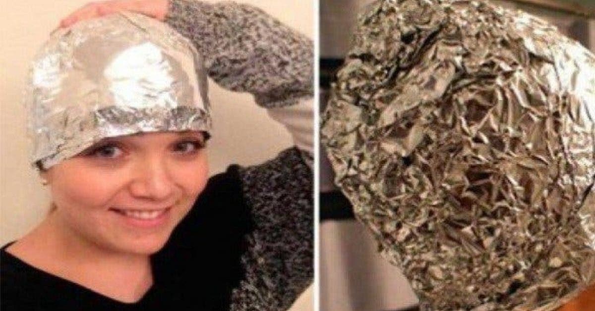Une femme met du papier aluminium sur ses cheveux