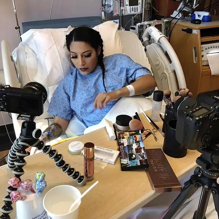 A woman putting on makeup in the hospital.