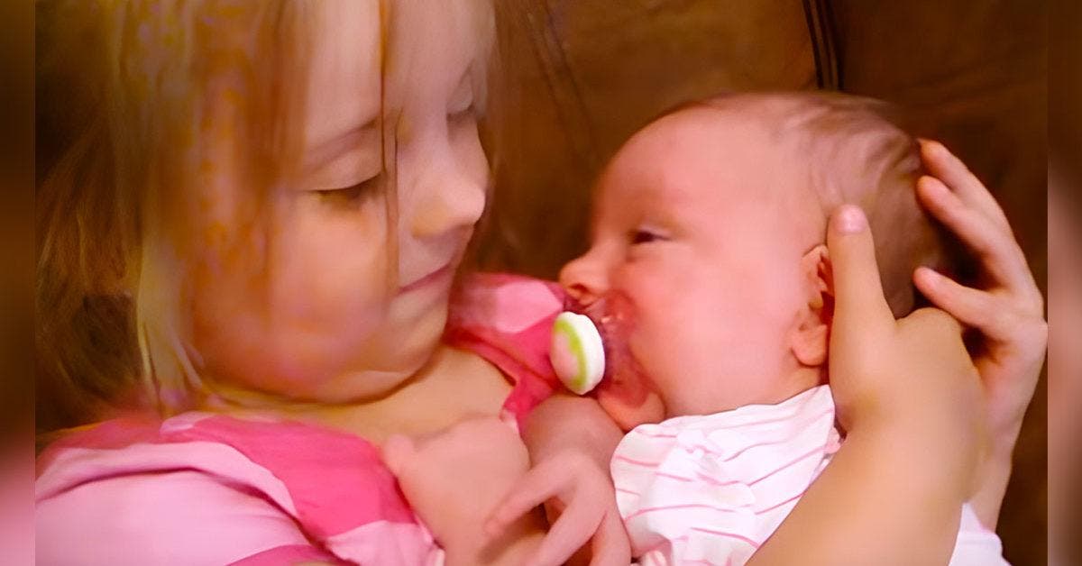 Une petite fille de 5 ans aide sa petite sœur à dormir d’une manière adorable