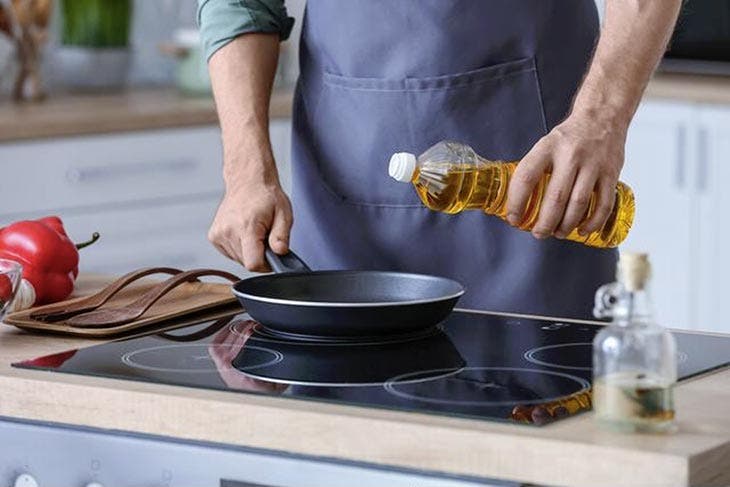 Versare l'olio da cucina in una padella