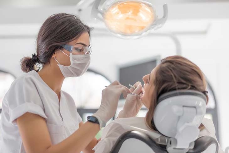 Un dentiste qui examine son patient