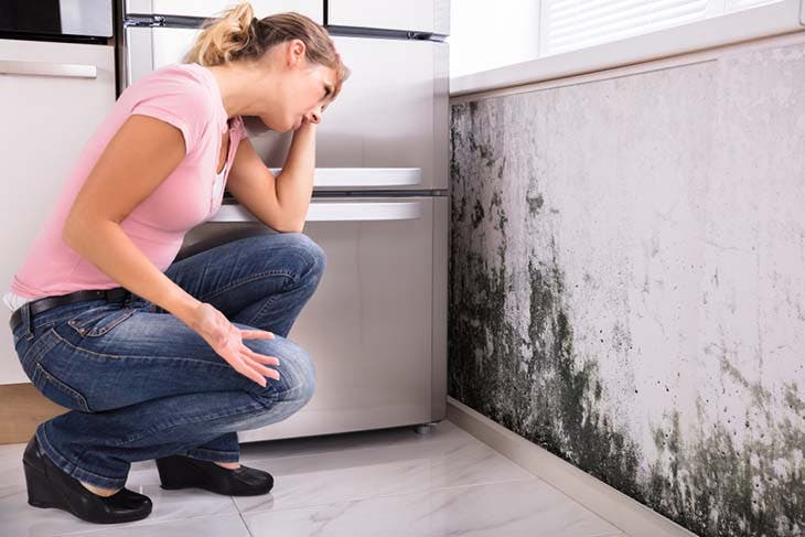 woman noticing mold in her kitchen