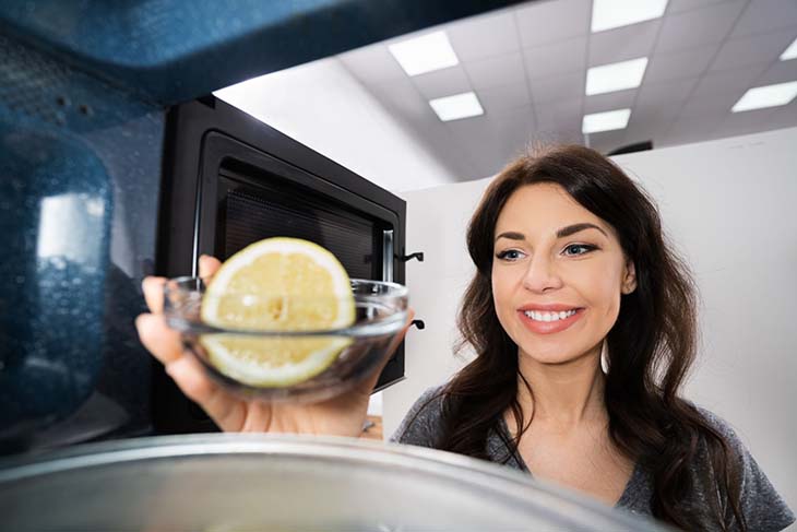 mujer limpiando horno con limon