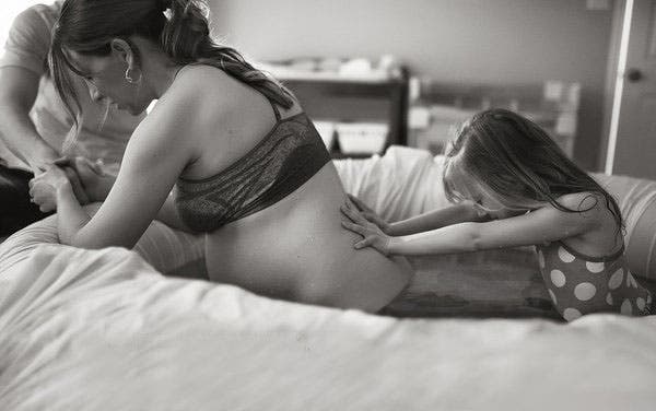Une fillette qui soutient sa maman pendant l’accouchement