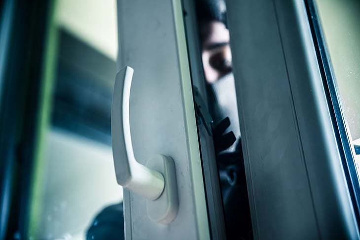 Un voleur qui ouvre la porte de la maison Un voleur qui ouvre la porte de la maison